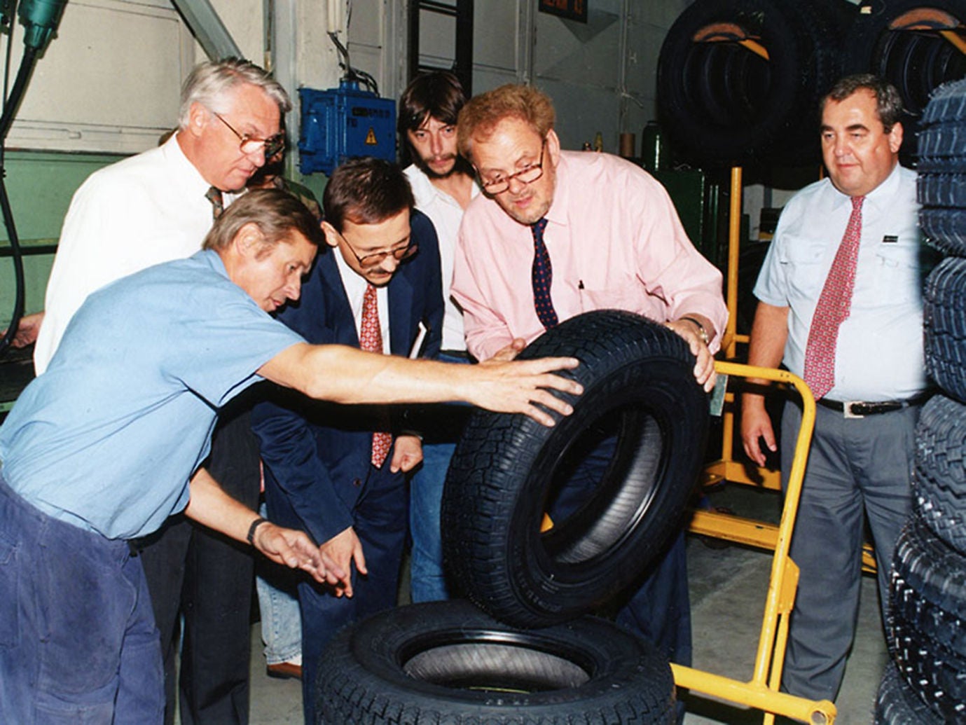 (foto antiga de homens avaliando um pneu Barum dentro da fábrica)